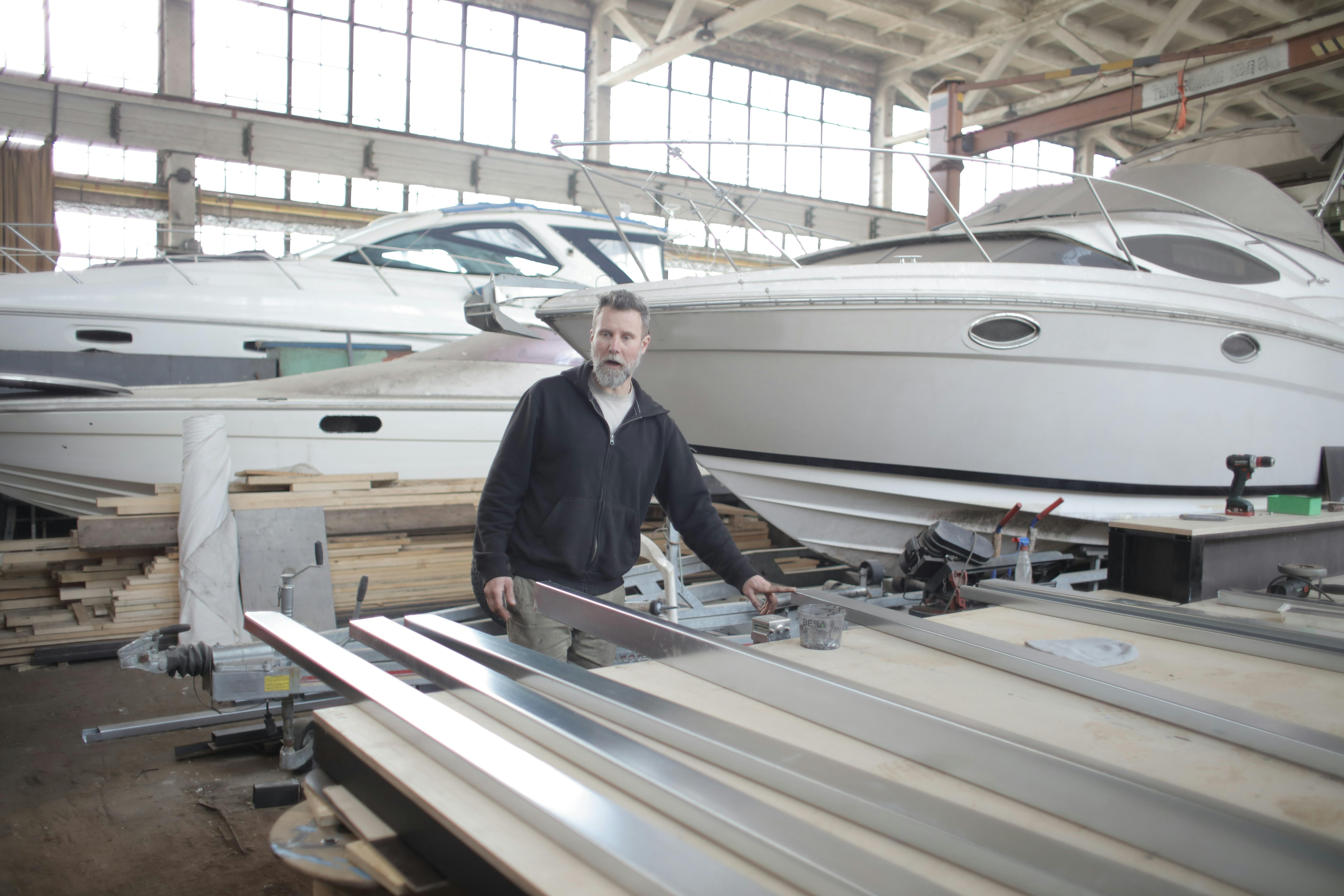 Gratuit Maître Masculin Dans Le Hangar Avec Des Bateaux à Moteur Photos